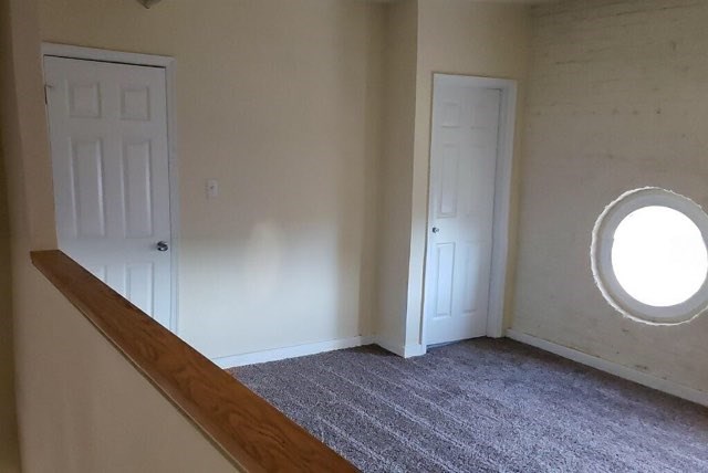 a white room with a window and a door and a carpet